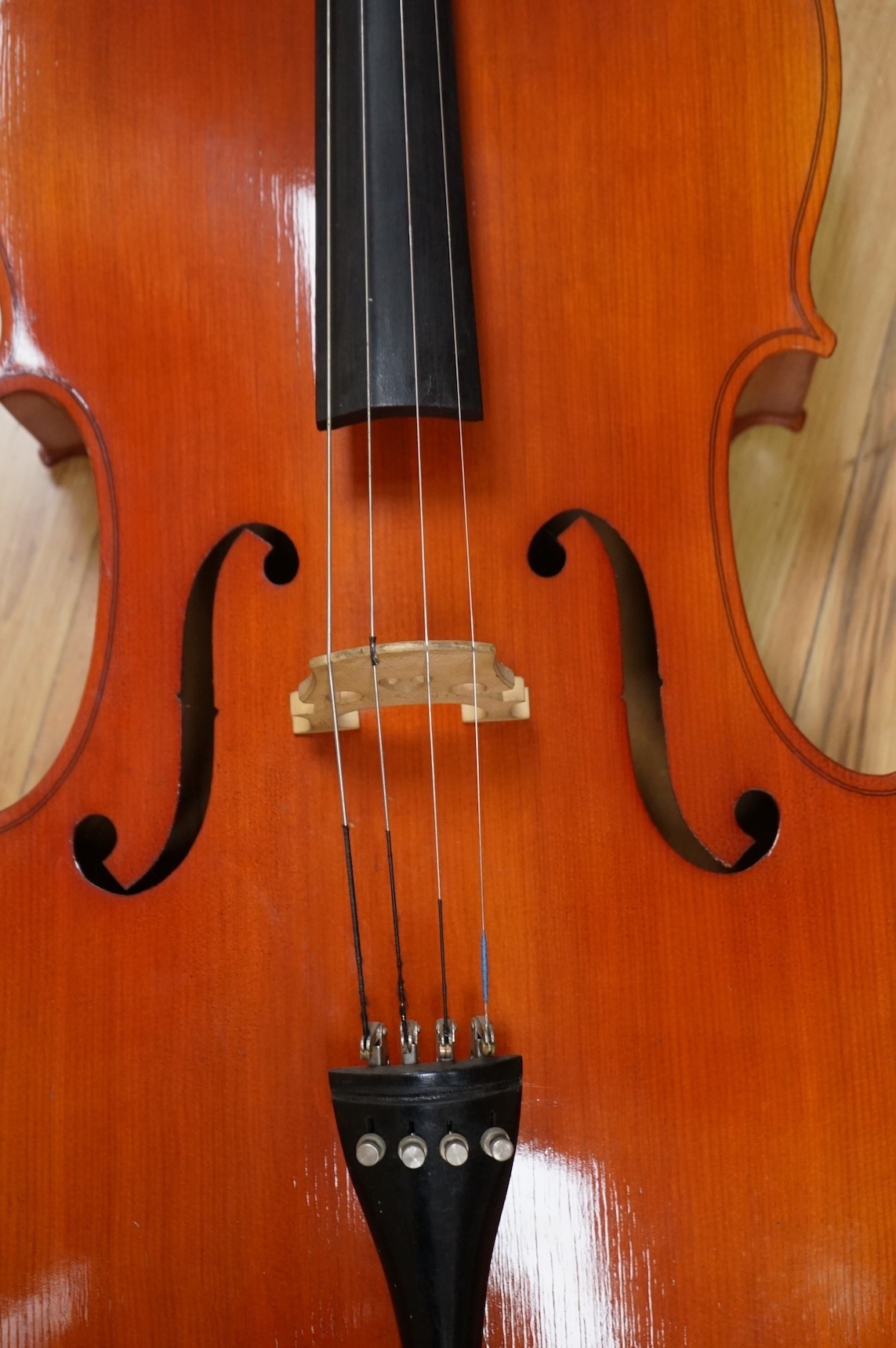 A modern student’s cello in a soft case and a student’s Spanish classical guitar